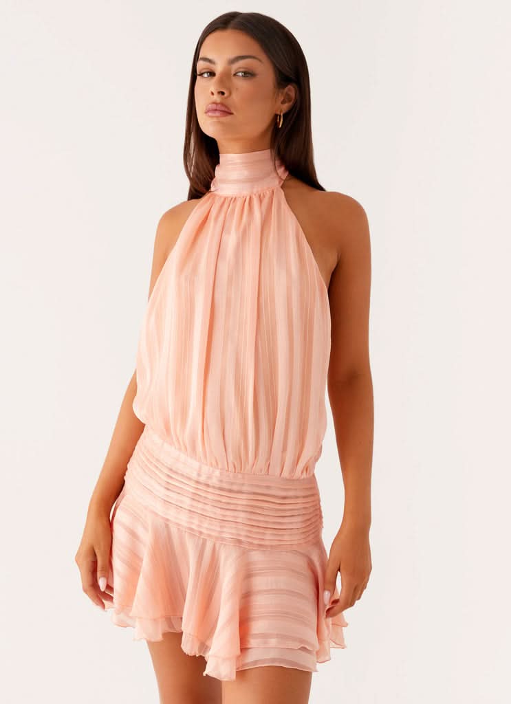 Blush pink pleated halter mini dress with gathered bodice and ruffled hem
