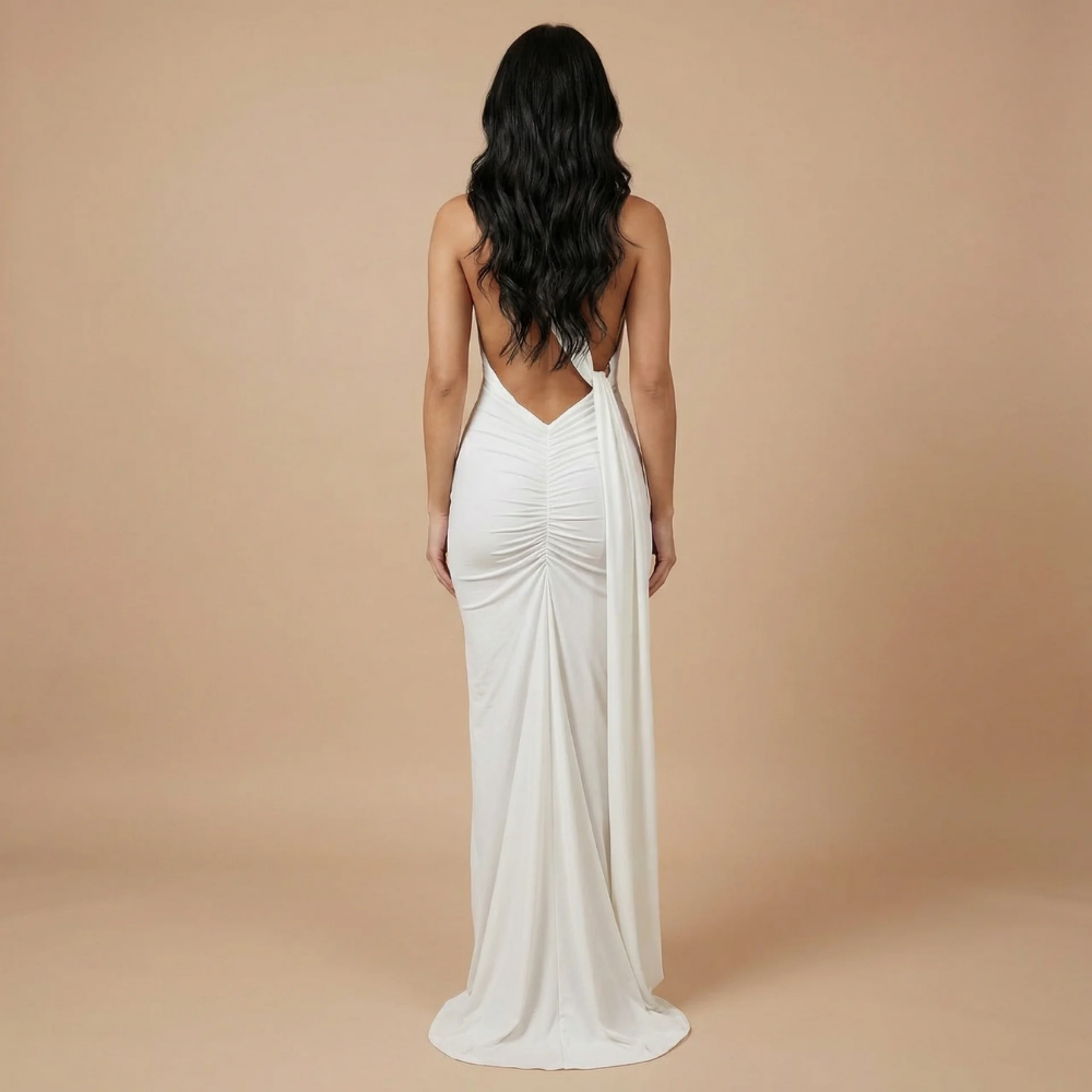 Back view of white draped maxi dress with plunging open back and flowing ruched fabric
