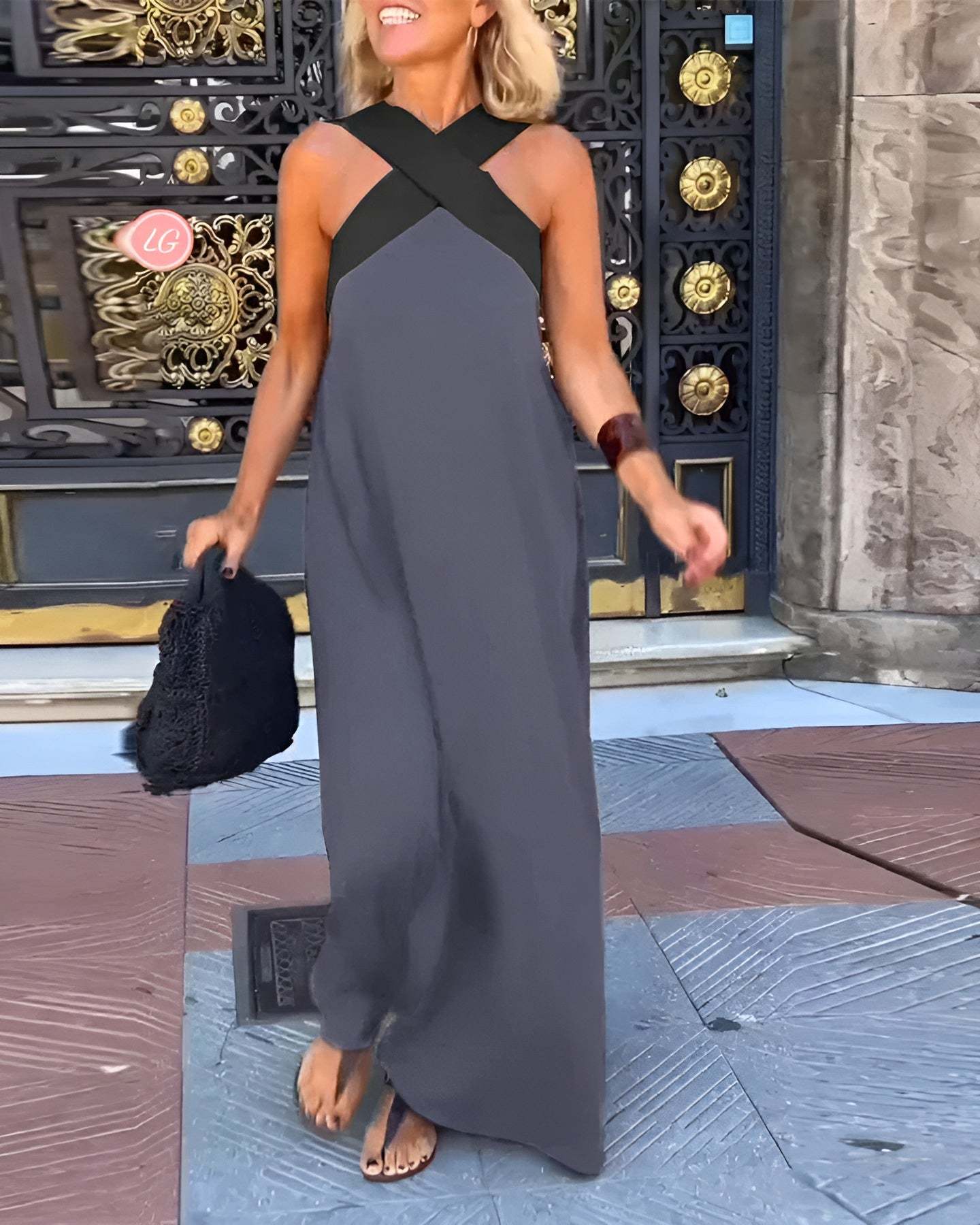 Gray sleeveless maxi dress with cross halter neckline and draped skirt
