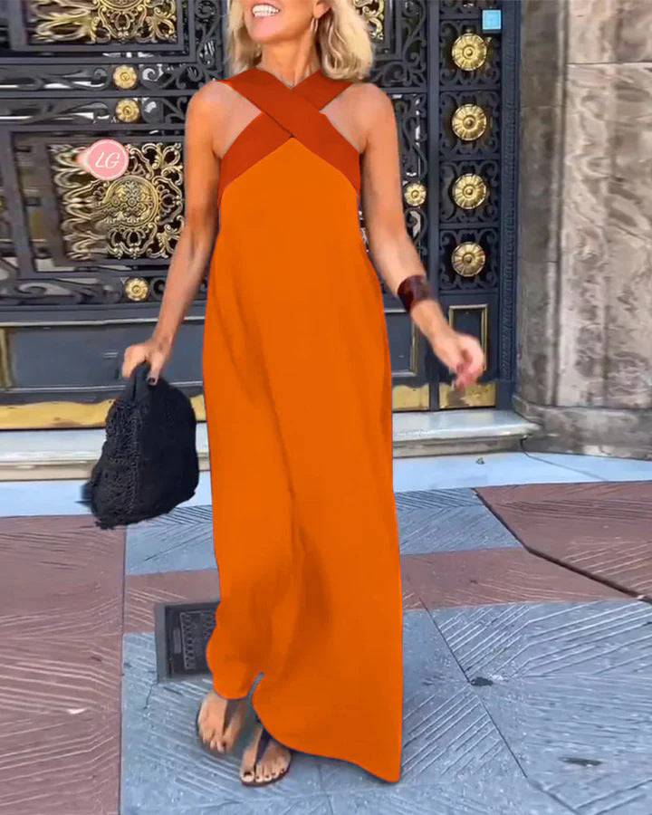Bright orange maxi dress with rust crossover straps and asymmetrical hem