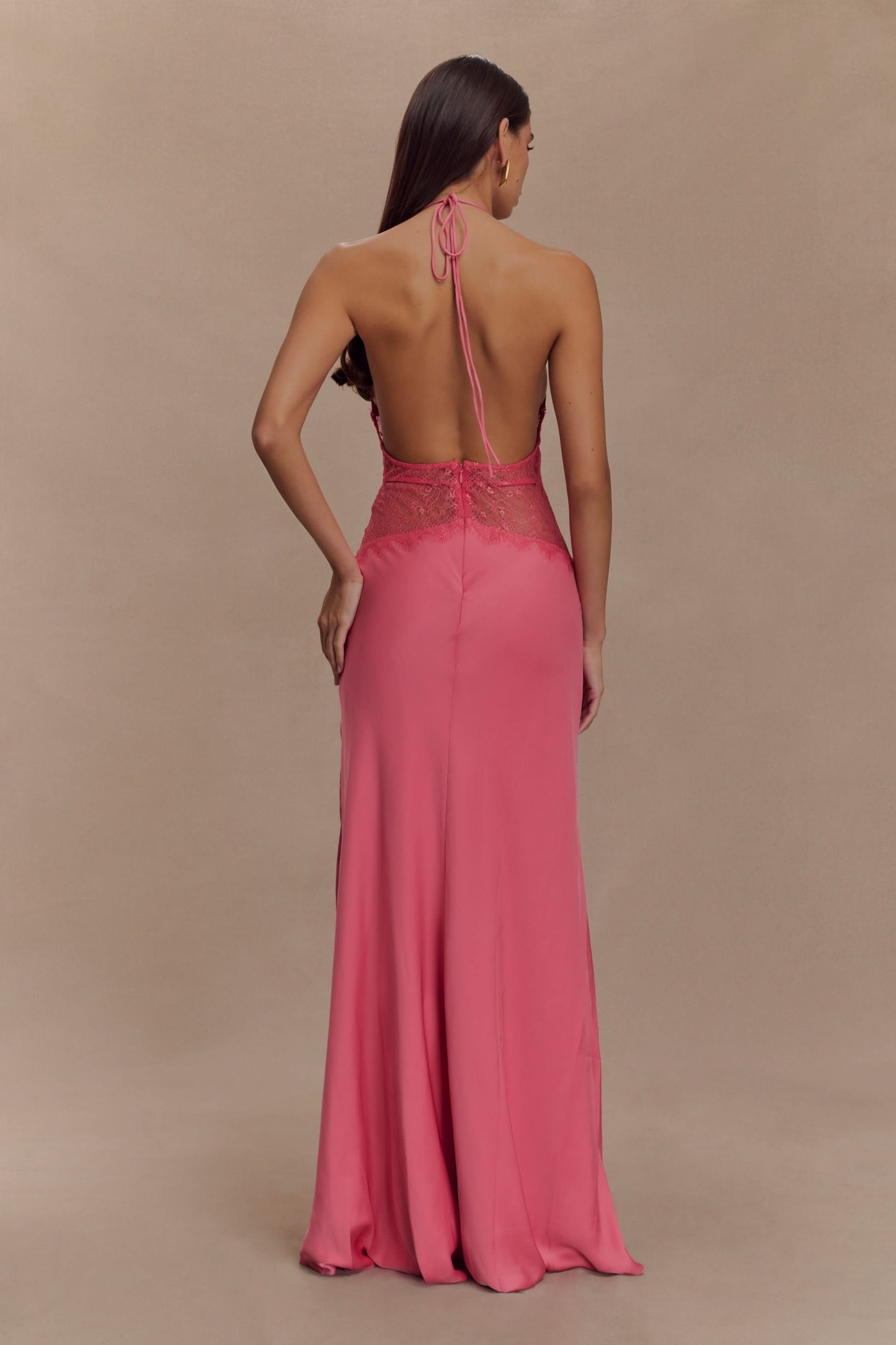 Back view of pink lace maxi dress with halter tie and flowing train