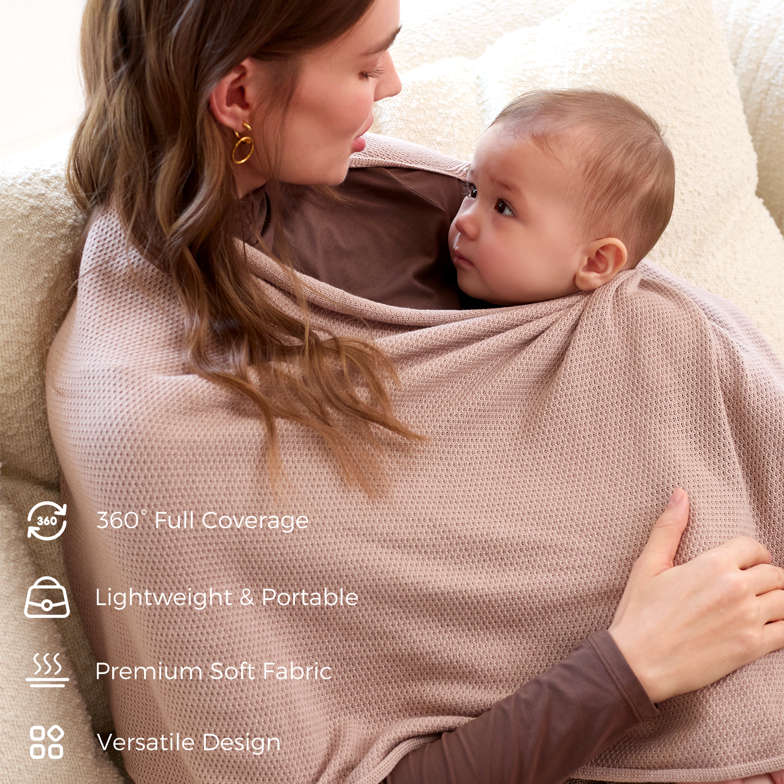 Close-up of taupe poncho wrapped around mother and baby on couch