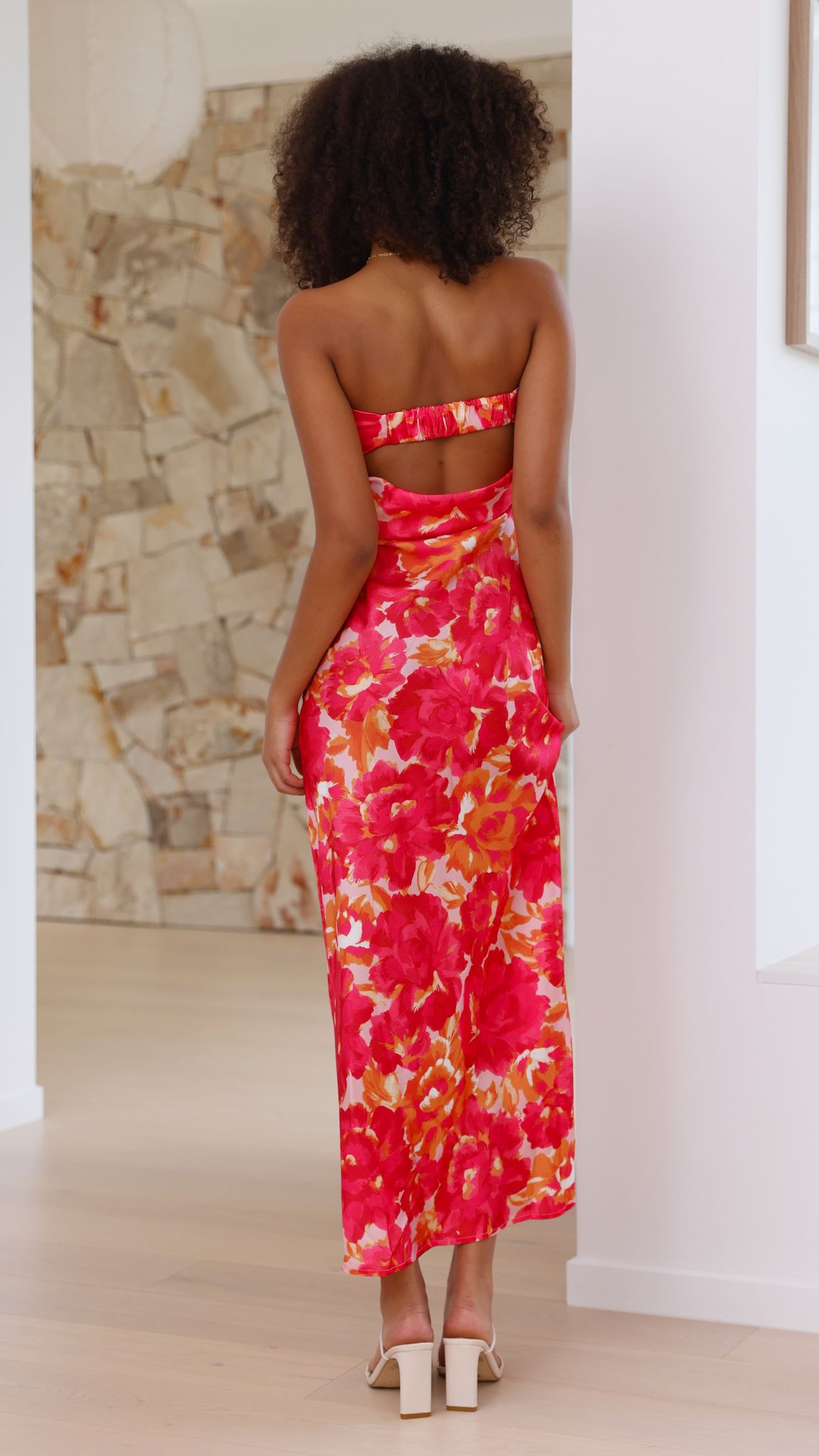 Back view of pink floral midi dress showing cutout waist and ruched details