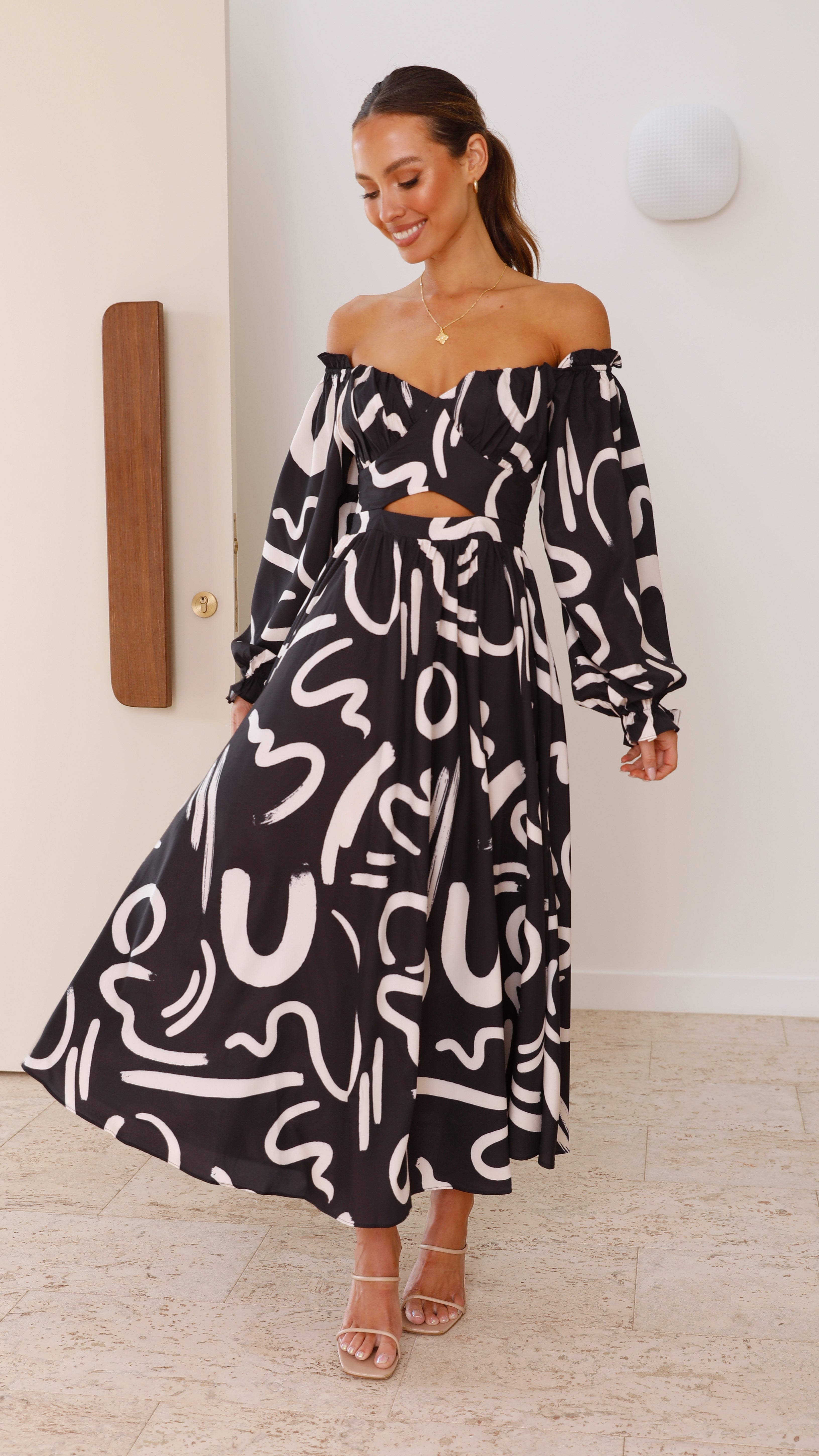 Abstract maxi dress with off-shoulder design, cutout waist, and voluminous sleeves
