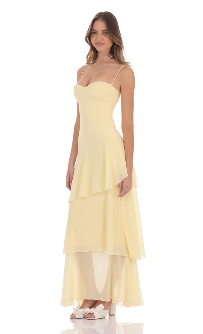 Side view of pale yellow wedding guest maxi dress with flowing ruffle skirt