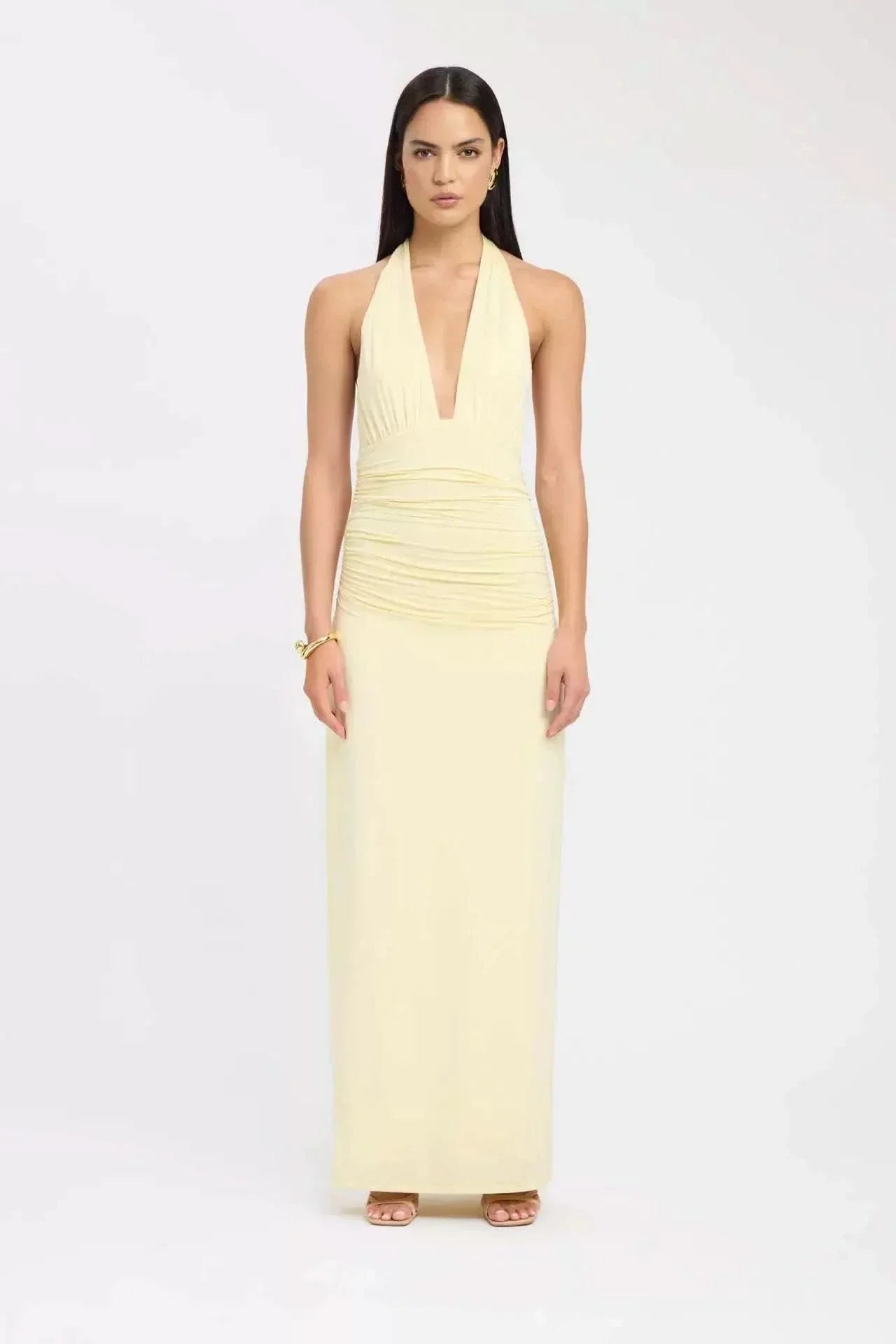 Pale yellow halter maxi dress with ruched waist and deep V-neck