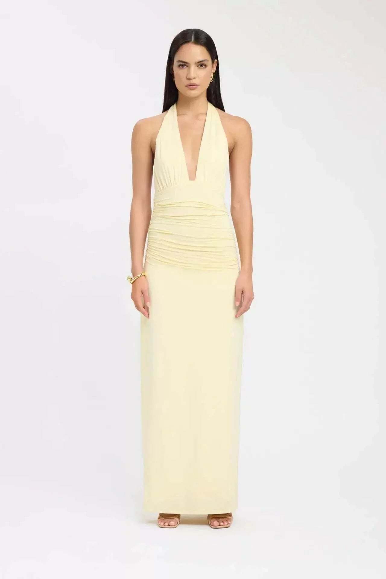 Pale yellow halter maxi dress with ruched waist and deep V-neck