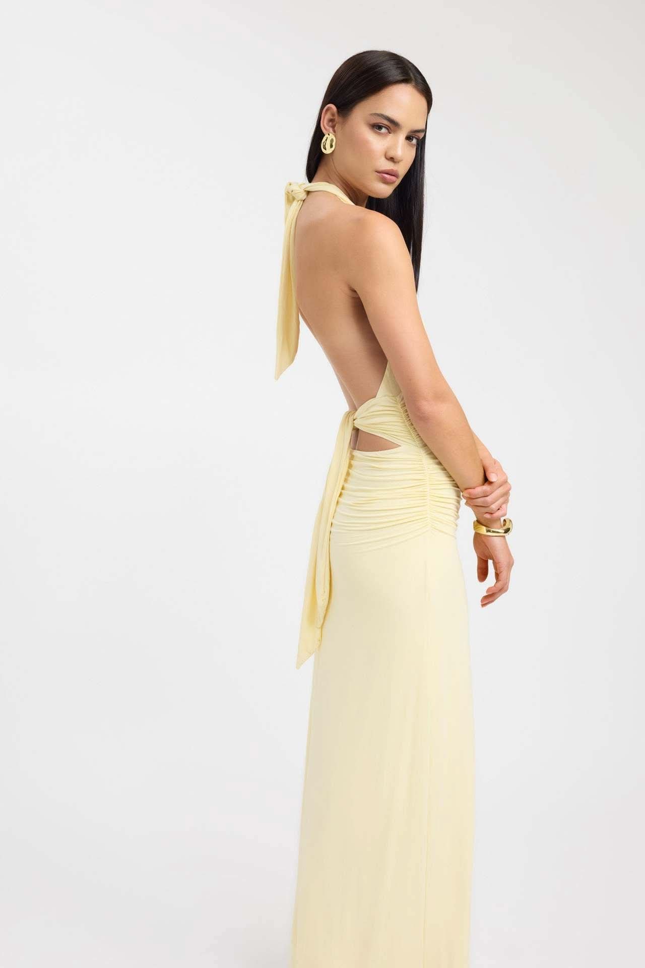 Side view of pale yellow maxi dress showing ruched details and tied back