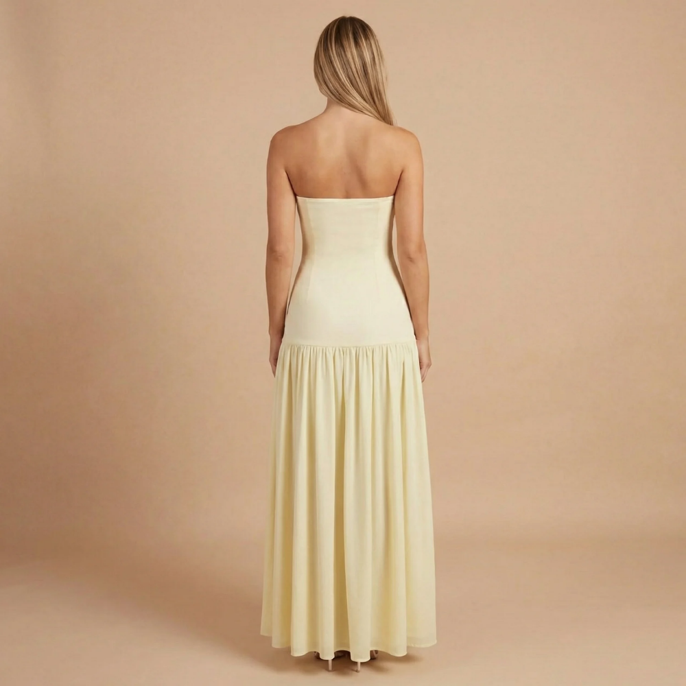 Back view of cream bandeau maxi dress with flowing pleated skirt
