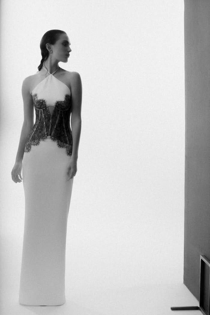 Side profile of white maxi dress with black lace waist and halter neckline