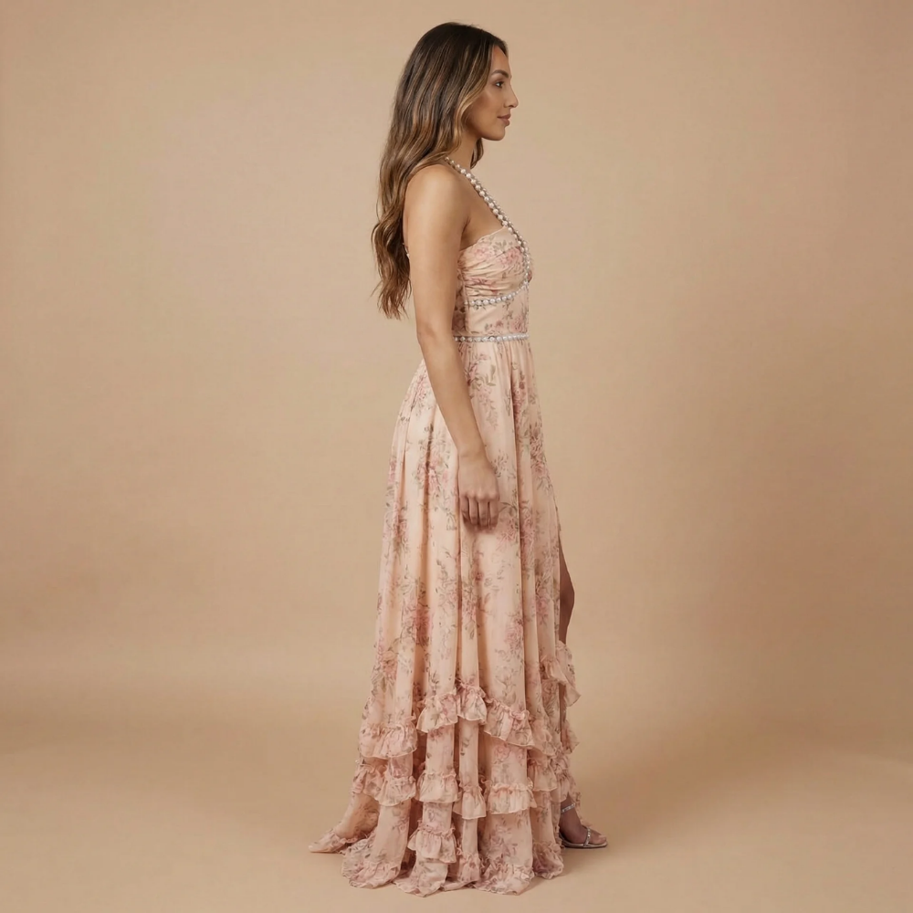 Side view of blush pink floral halter dress with layered ruffles and slit
