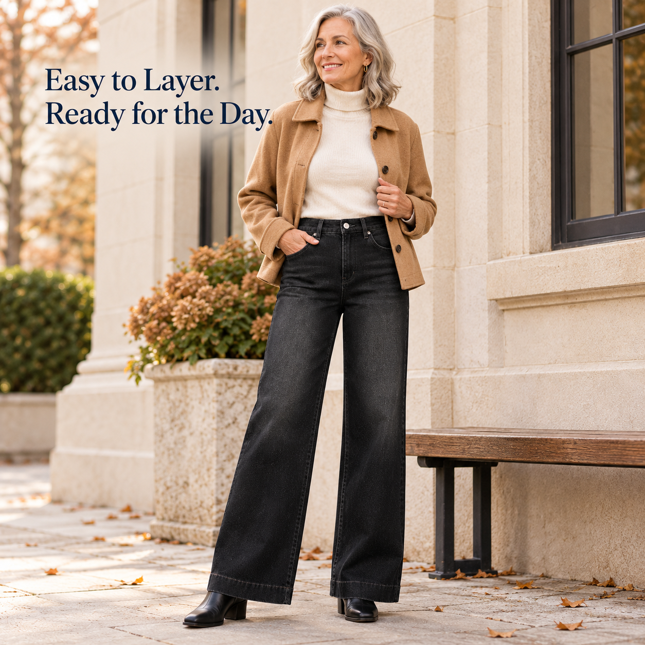 Black wide-leg jeans styled with a camel jacket and ankle boots