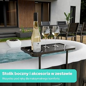 Tekst brzmi: „Stolik boczny i akcesoria w zestawie Wszystko pod ręką dla maksymalnego komfortu” (język polski). Nowoczesne patio z czarnym stołem, butelką wina, kieliszkami i leżakami widocznymi we współczesnej aranżacji mebli ogrodowych.
