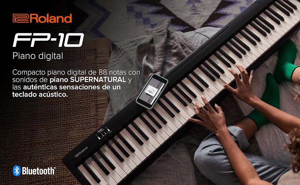 El texto dice «Roland FP-10 Piano Digital», «SUPERNATURAL», «Bluetooth». Se está tocando un teclado de piano digital, que muestra teclas en blanco y negro con una interfaz moderna.