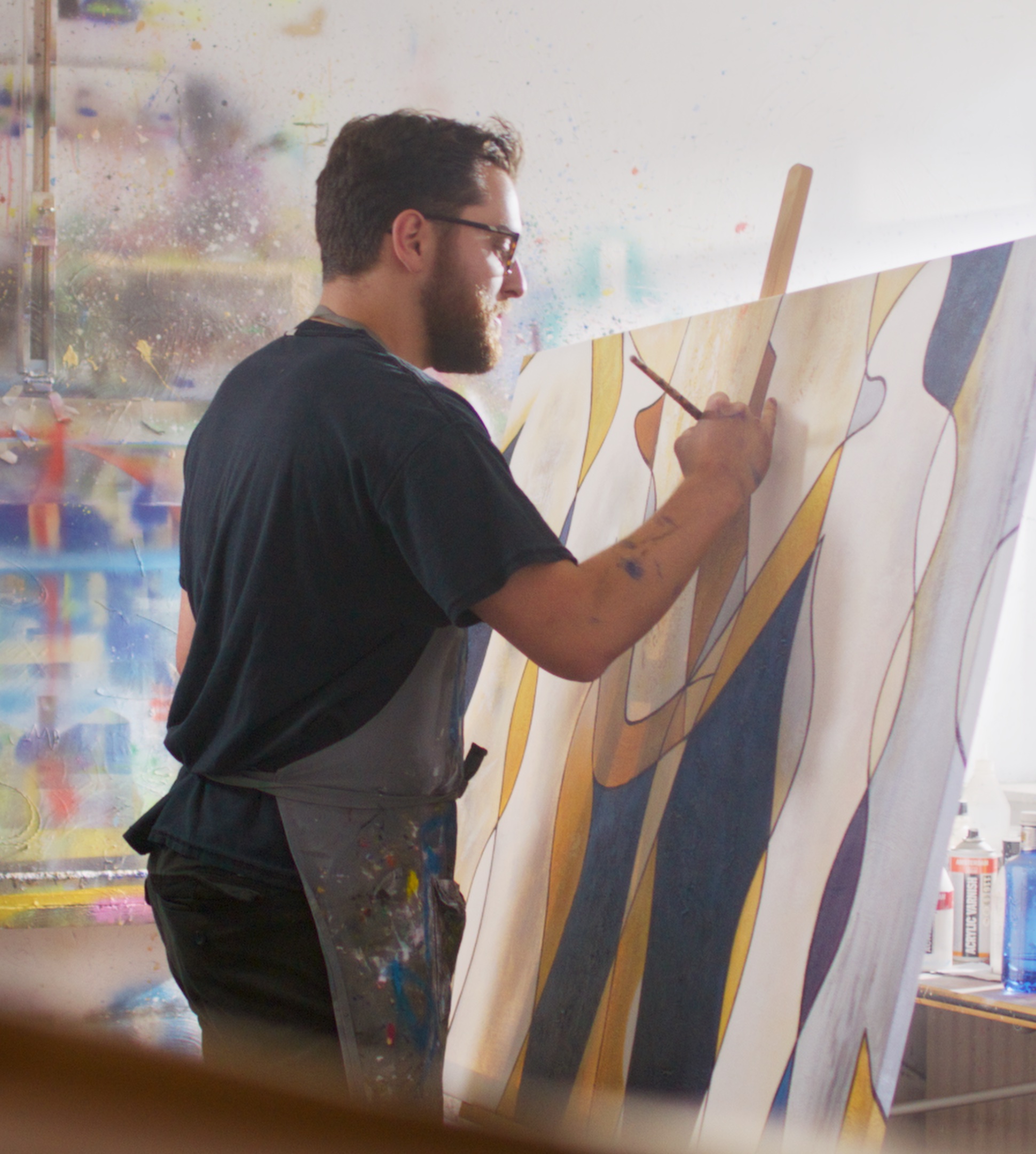 Artist hand-painting a geometric canvas with a brush