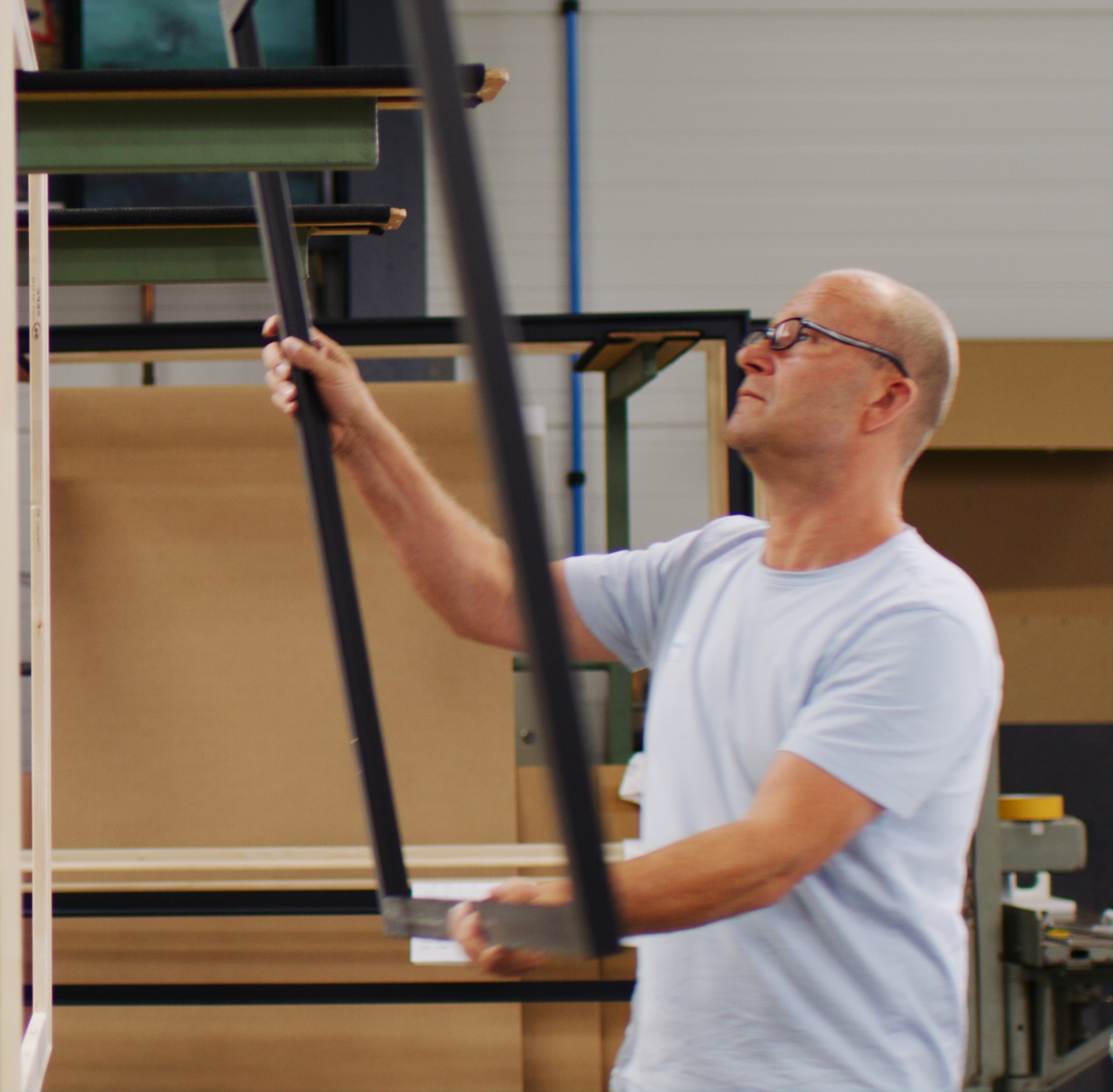 Craftsperson handling a black rectangular frame in a workshop