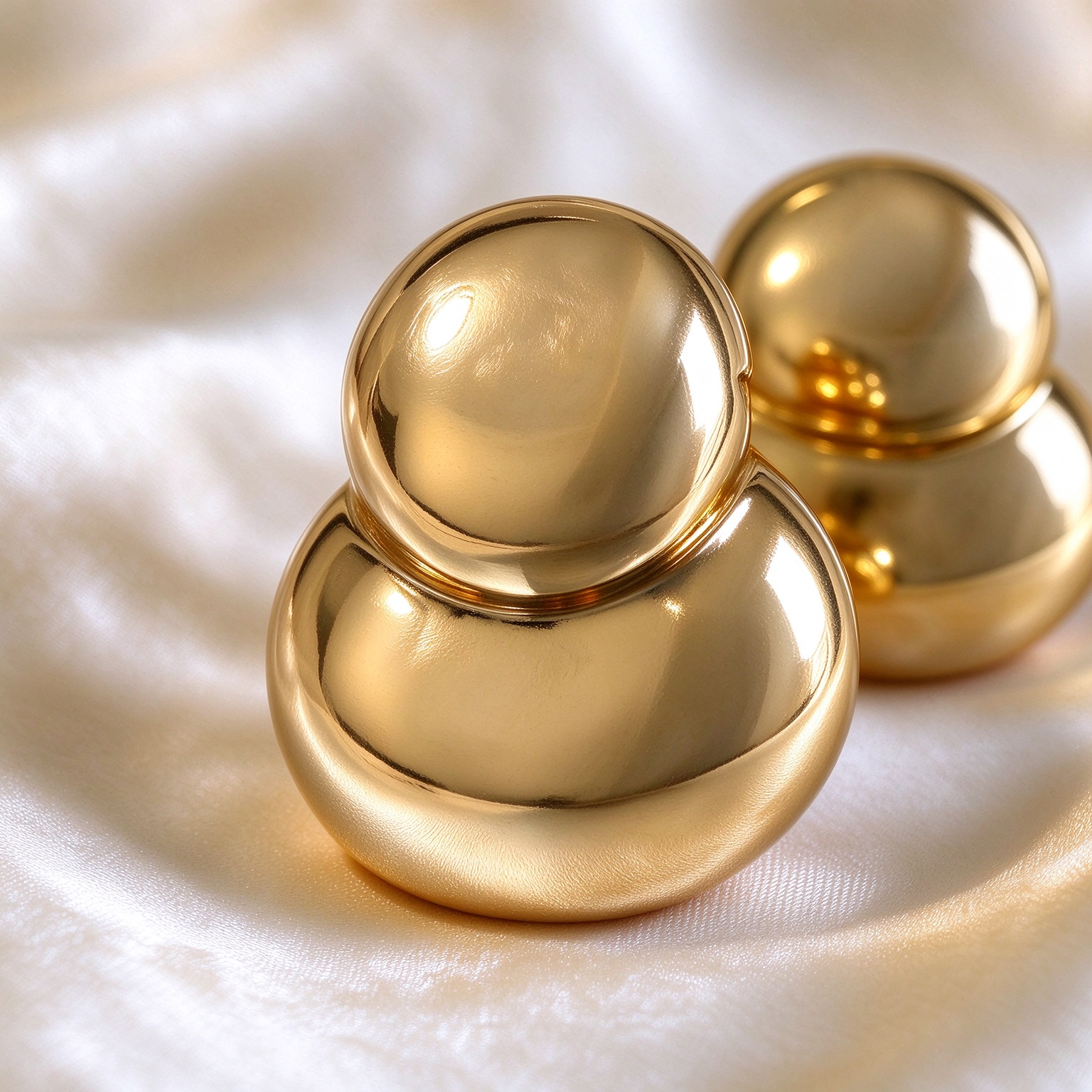 Close up detail of gold double bubble earrings, polished mirror finish, rounded gold shape, fine jewelry detail shot
