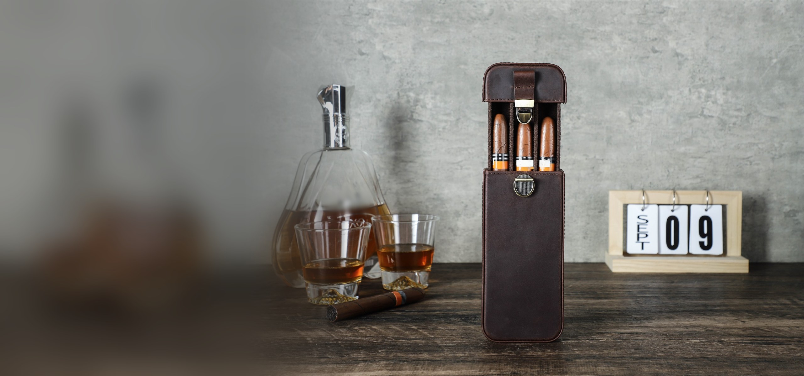 CF5018 3-cigar slim leather case standing open with three cigars, beside a decanter and whisky glasses
