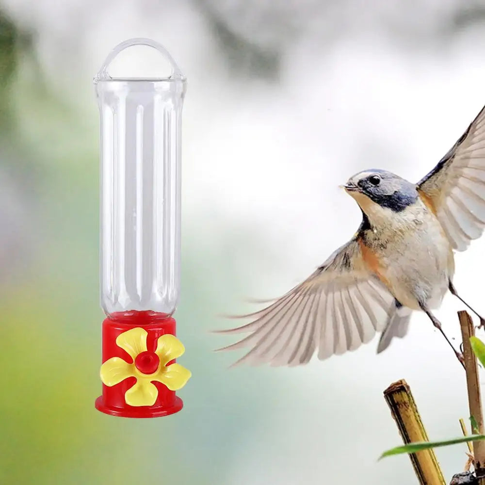 Four hummingbird feeders arranged on a wooden table outdoors