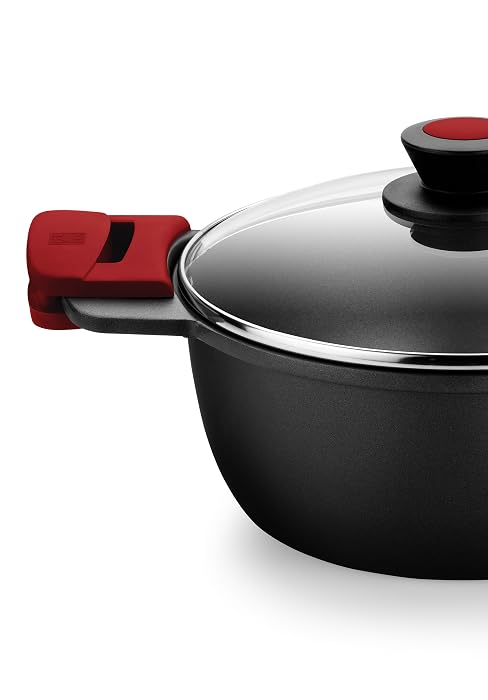 Olla antiadherente negra con asas rojas, tapa de vidrio con pomo negro y lados redondeados para una cocción versátil.