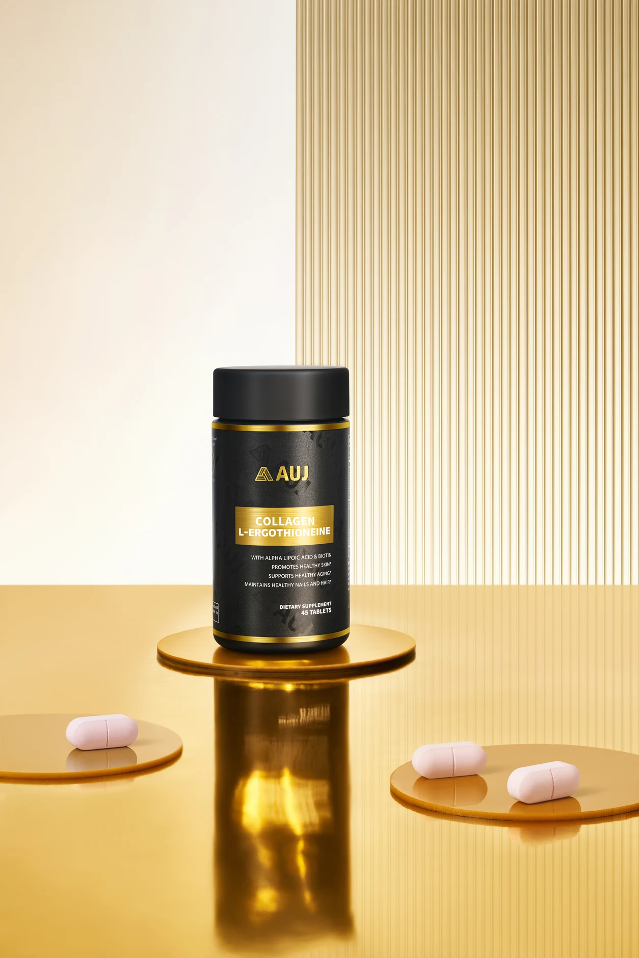 Original AUJ photograph of the Black Gold Bottle and pink tablets on a gold studio set