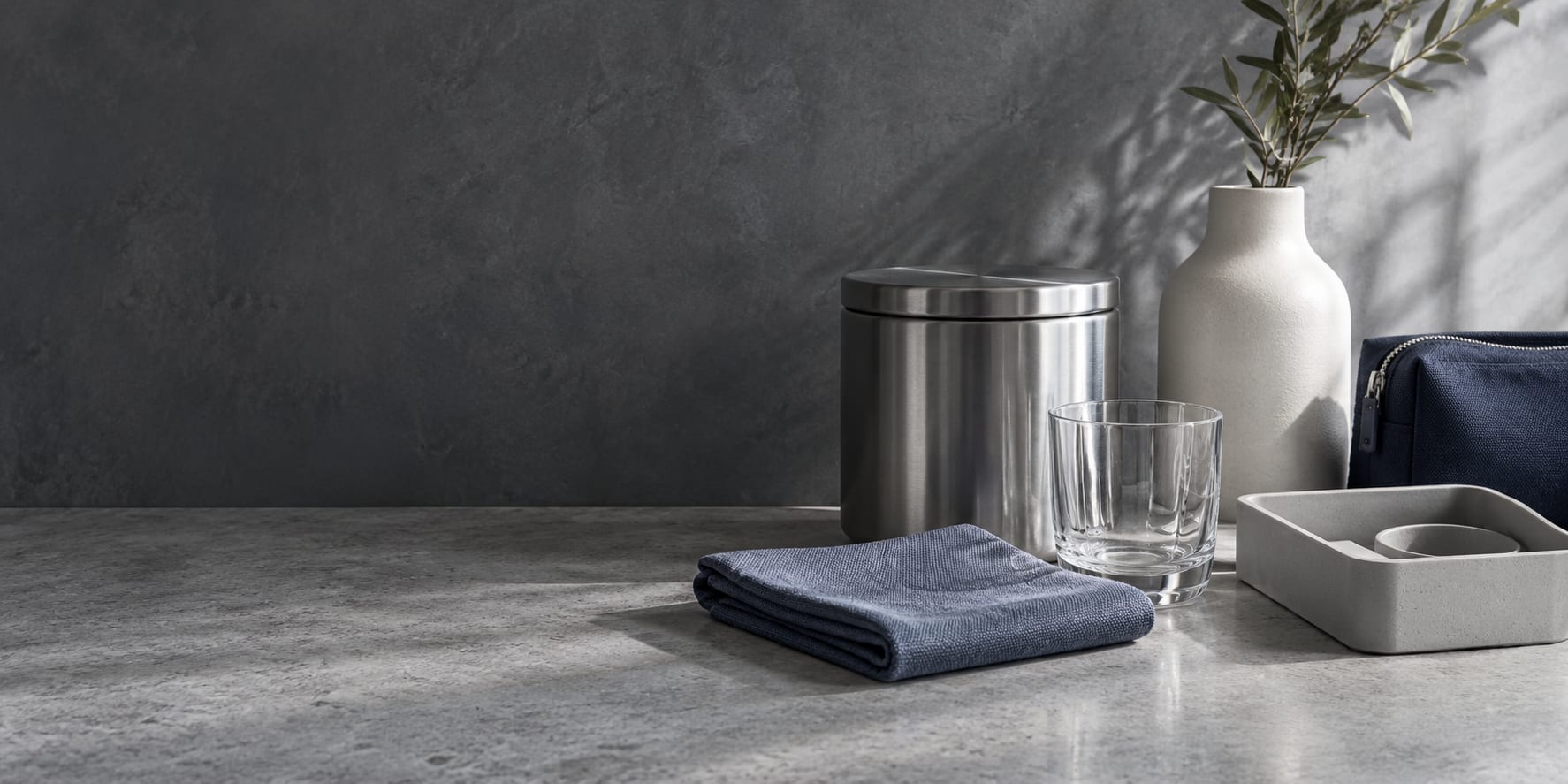 Glass, stainless steel, slate blue cloth and everyday organizers in a cool studio still life