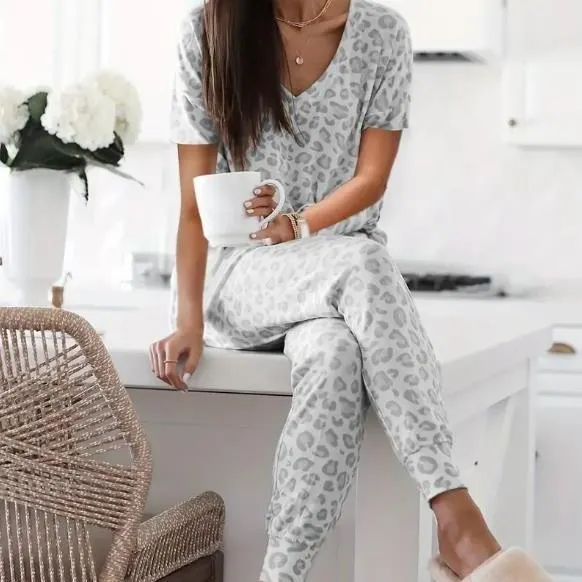 Women's V-NeckLeopard Print Loungewear Set. This relaxed-fit two-piece features a short-sleeve top and pants for effortlessly chic, casual comfort.