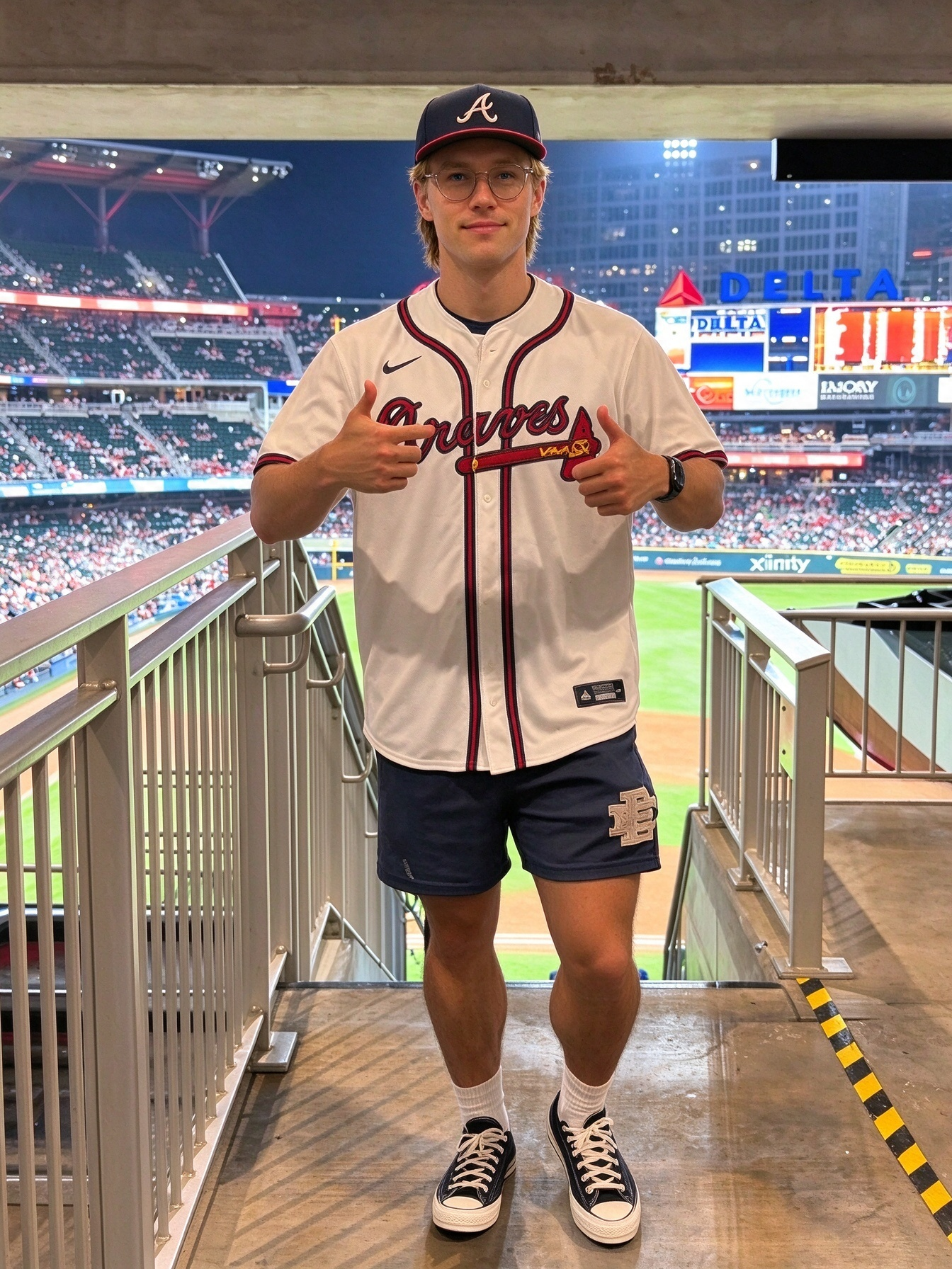 BaseballKitShop model in Los Angeles Dodgers grey baseball jersey, blue LA cap, black casual shorts, and white sneakers streetwear collection.