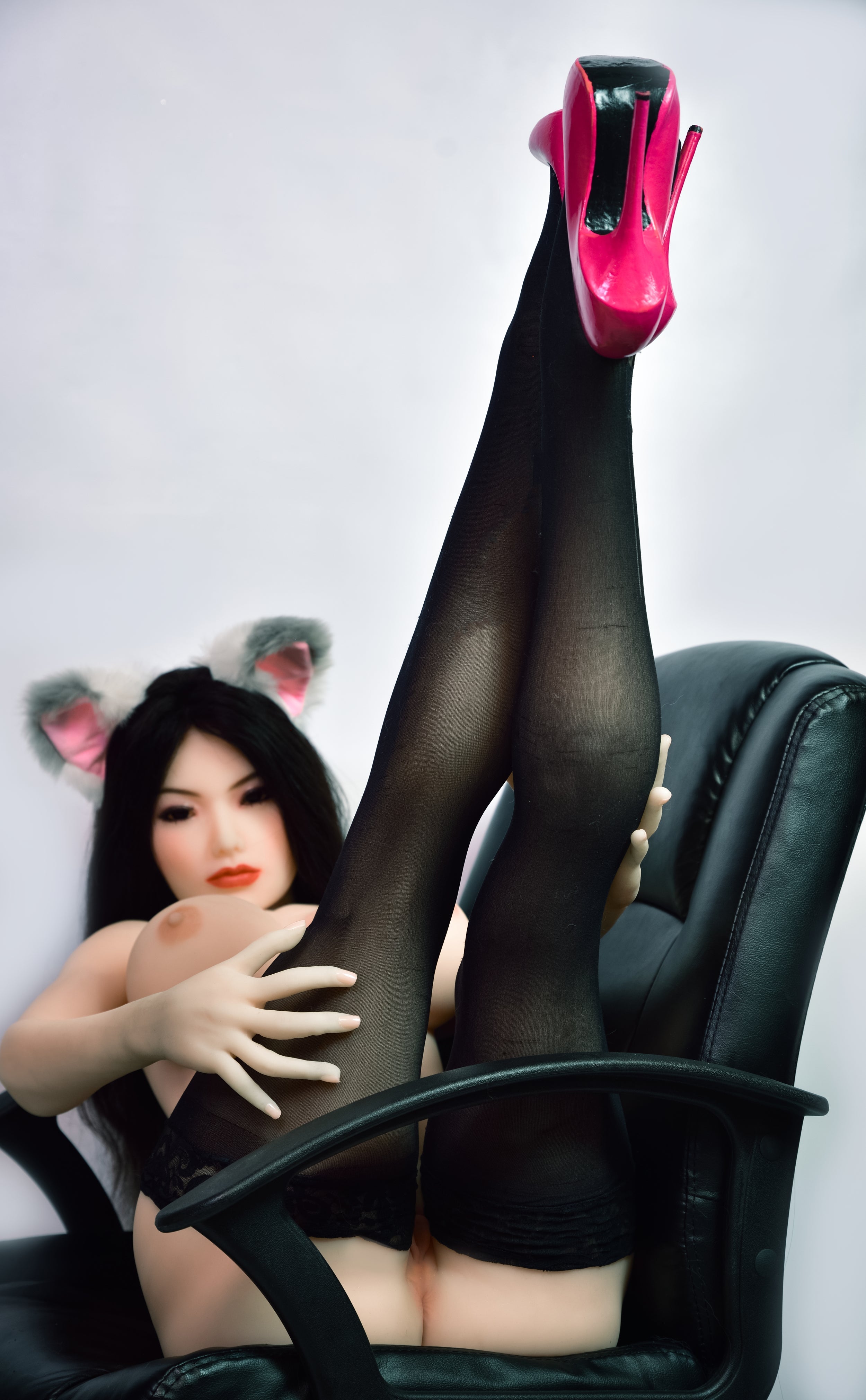 150cm sex doll with black hair, animal ears, wearing black stockings and pink heels, in a black office chair, lifting legs upwards
