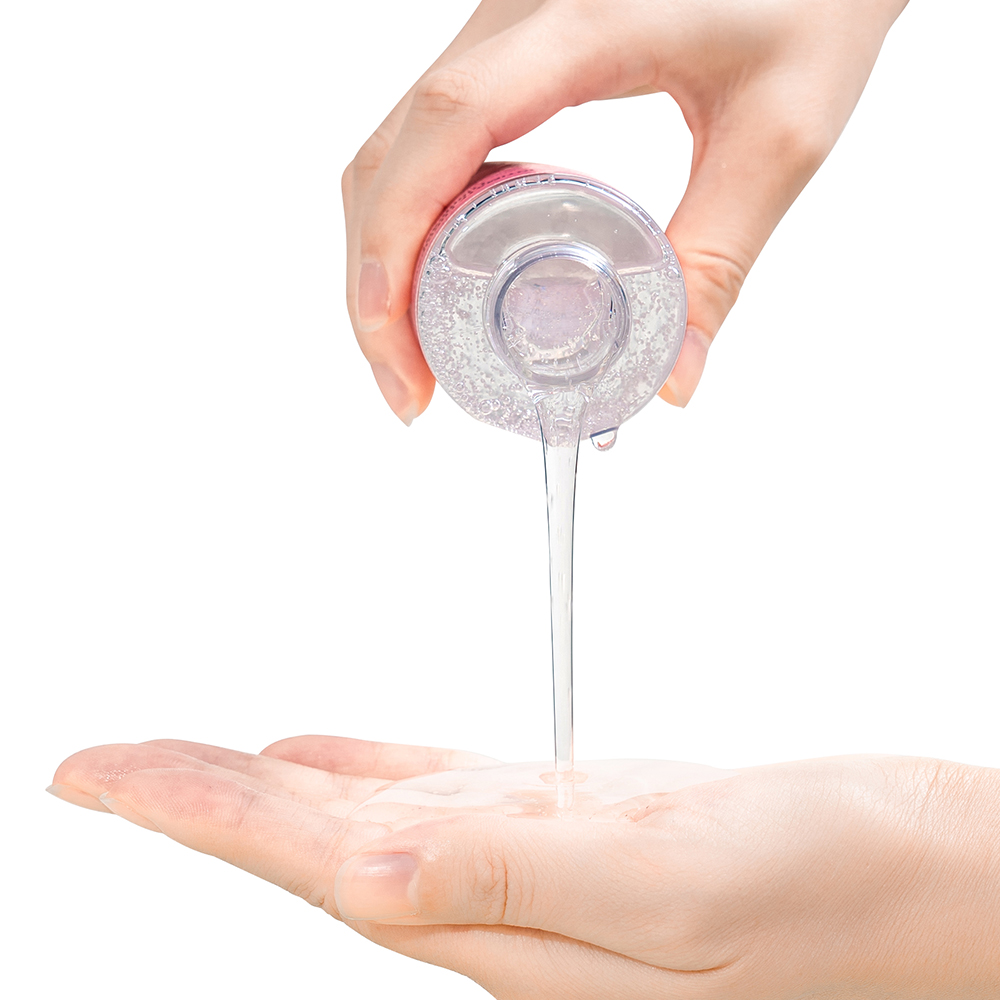 Hand pouring clear water-based lubricant into an open palm