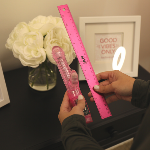 Vibrator in hand next to ruler.
