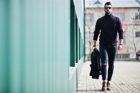 Male model with great physique, wearing purple turtleneck and ripped jeans in the street 