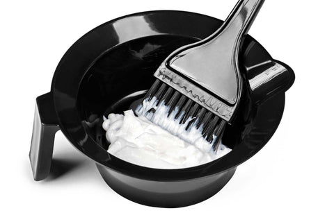 Hair dye in black container with application brush