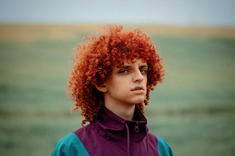 Young red-head in jacket with full curly hair